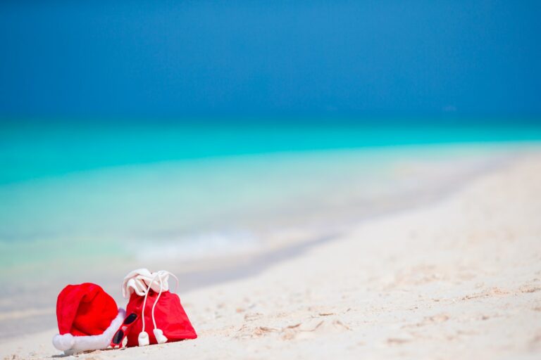 Christmas accessories on white beach. Xmas travel vacation and travel cuprise concept. Beach